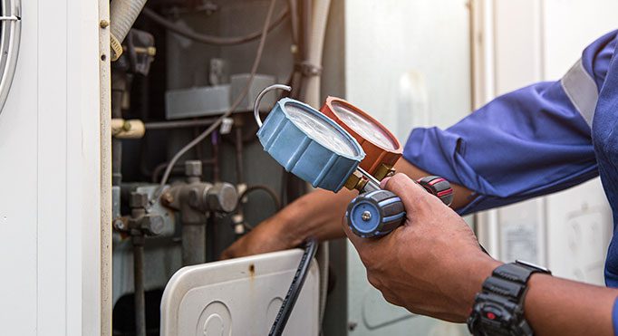 Heat and Air Conditioning, HVAC system service technician using measuring manifold gauge checking